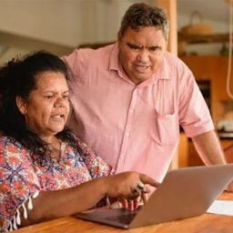 Older hispanic couple researching on laptop