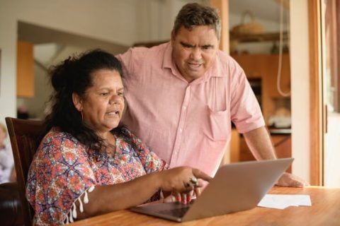 Older hispanic couple researching on laptop