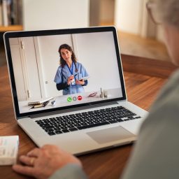 Senior woman on call with doctor on computer.