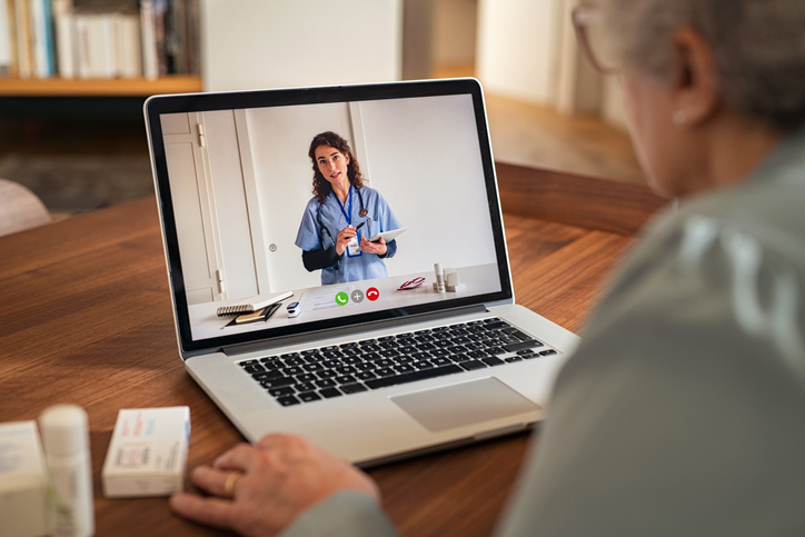 Senior woman on call with doctor on computer.