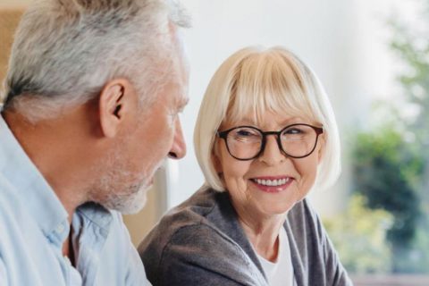 Senior couple smiling and looking over medical paperwork