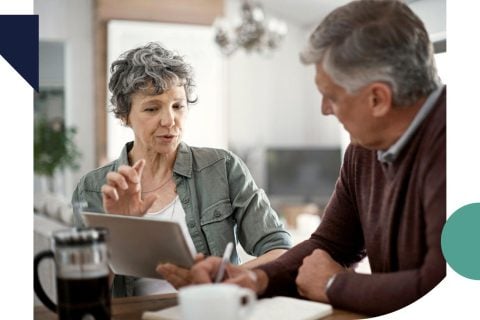 mature couple talking while using a digital tablet to learn about annuity riders