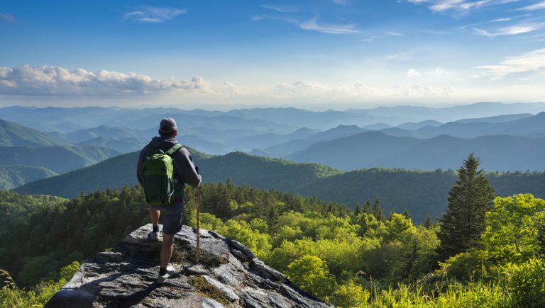A hiker pauses to look at a view of the mountains near Asheville, North Carolina