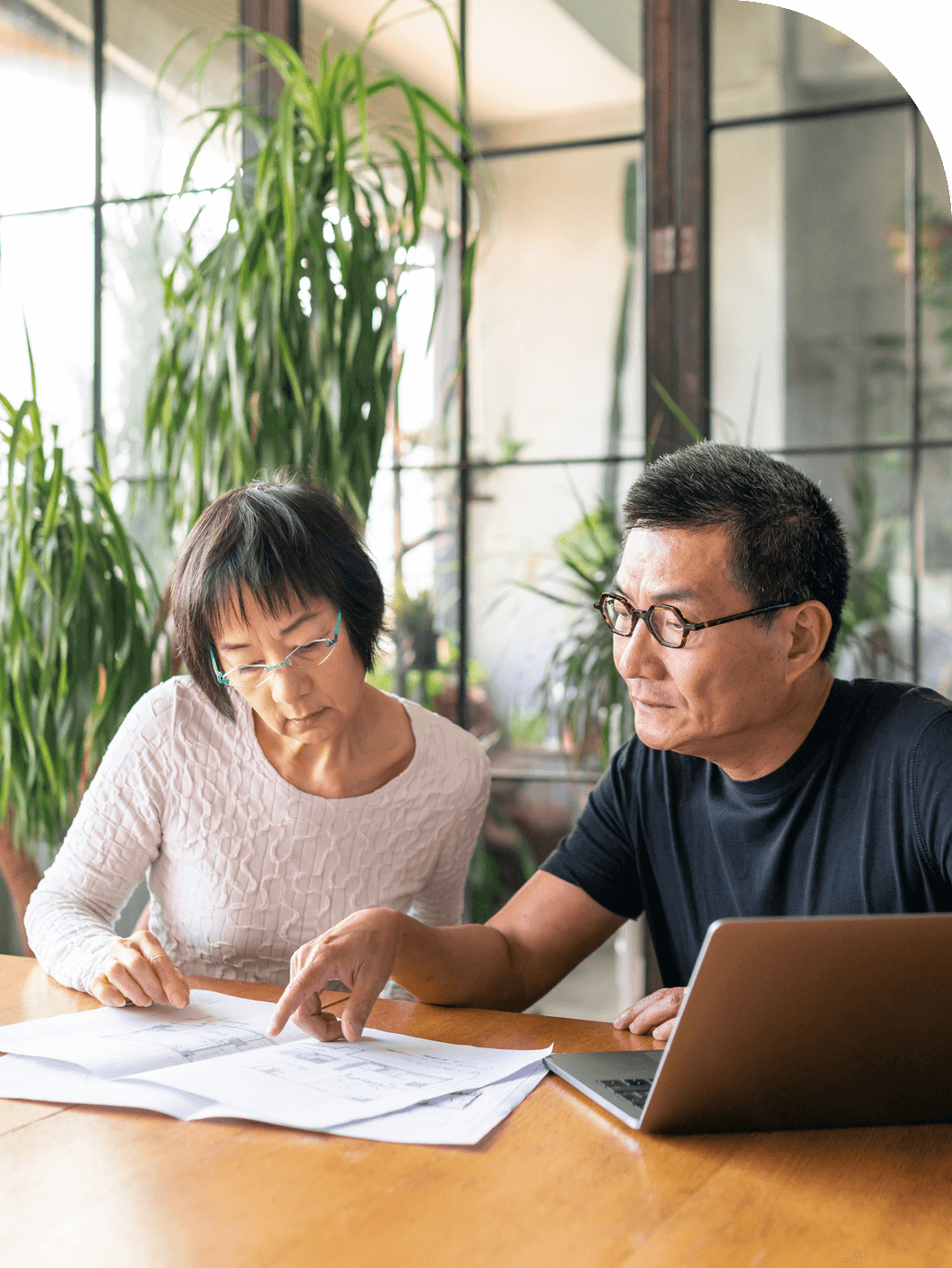Asian couple using computer and looking at paperwork