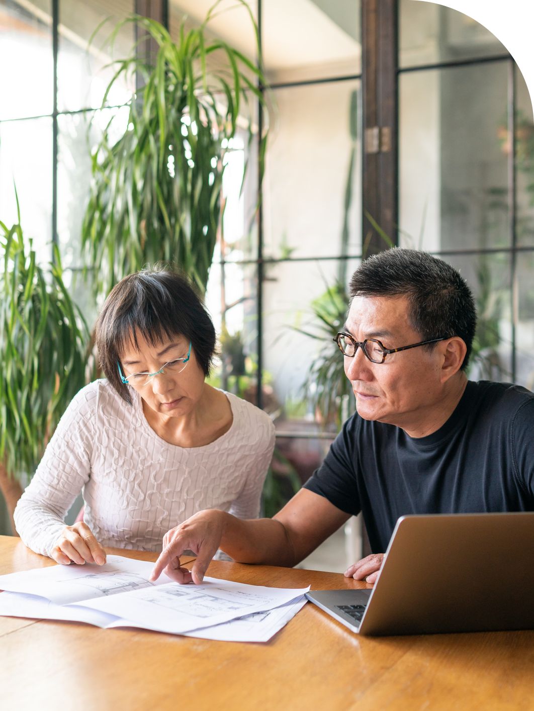 Asian couple using computer and looking at paperwork