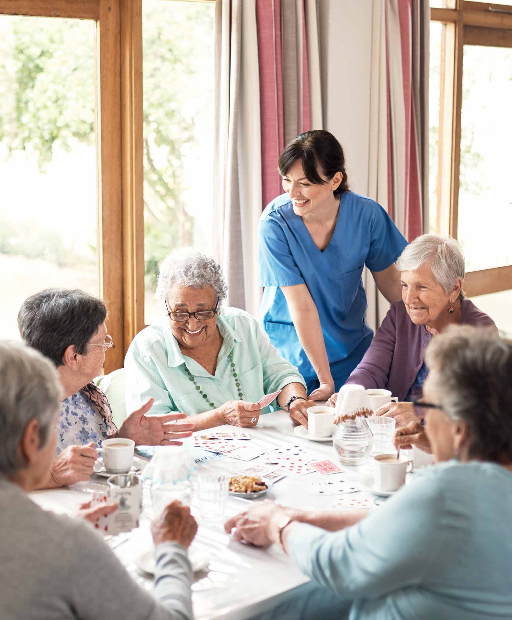 Candid shot of joyful senior residents at a nursing home playing a card game