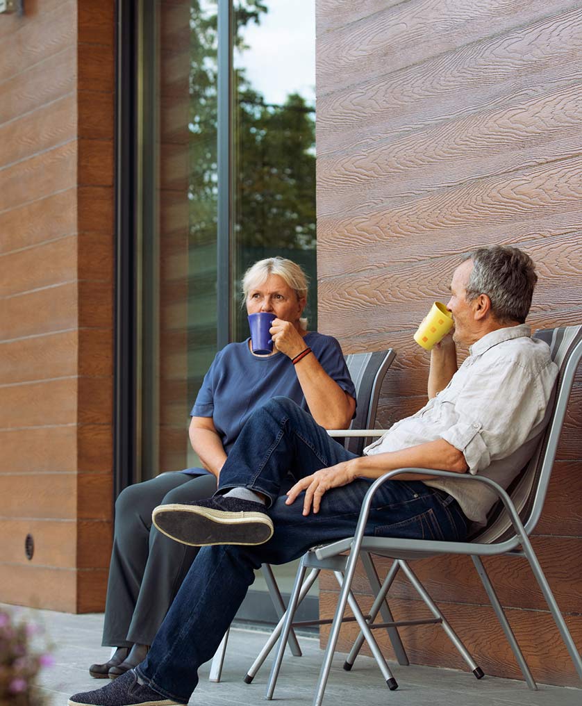 Senior couple drinking coffee on their front porch