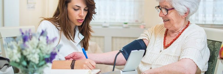 doctor helping older woman at home