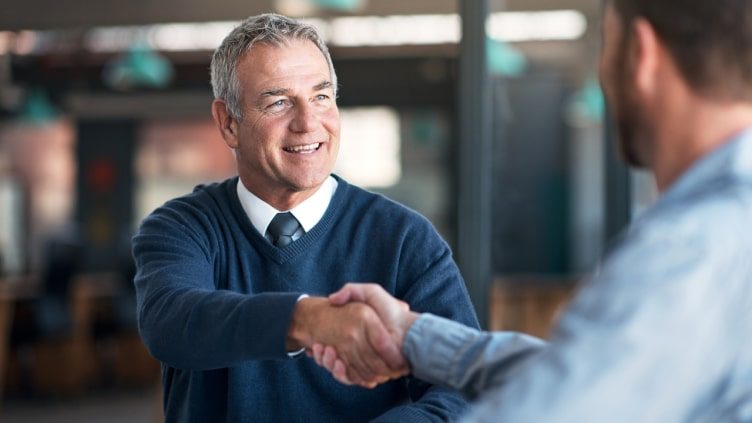 Older man shaking hands with advisor