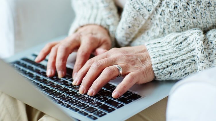 Older woman typing on laptop