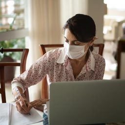 Older woman in masking writing