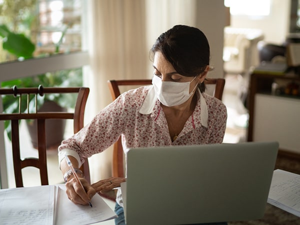 Older woman in masking writing