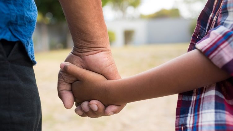 Boy and grandfather holding hands