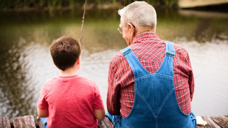Grandfather fishing with grandson