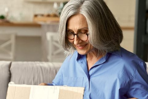 Elderly woman packing up a box