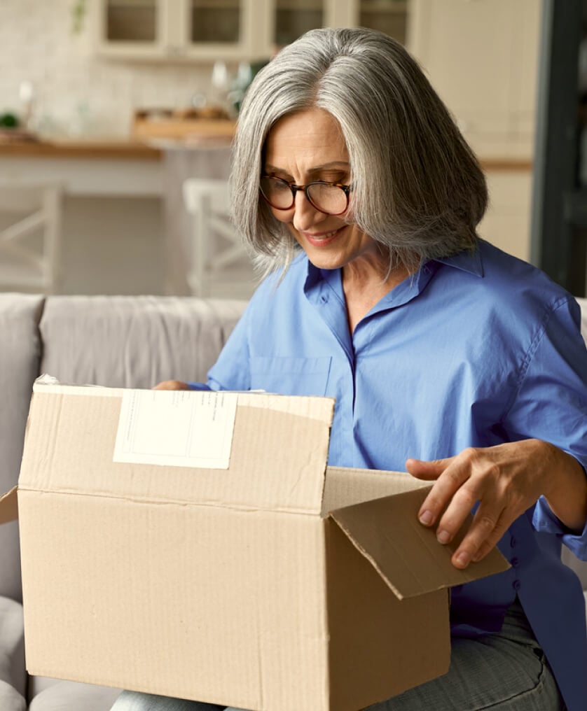 Elderly woman packing up a box