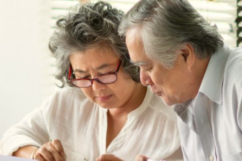 Elderly couple reading documents at a table