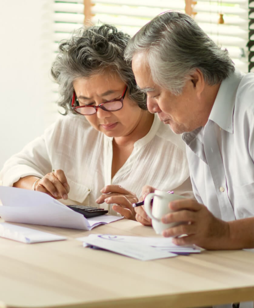 Elderly couple reading documents at a table