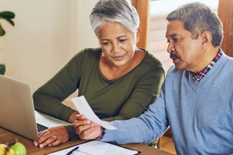 Elderly couple working on taxes at the dining room table