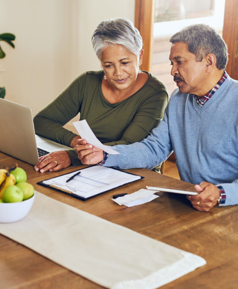 Elderly couple working on taxes at the dining room table