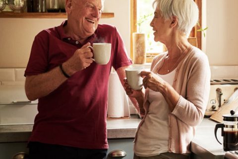 Elderly couple enjoying coffee in the kitchen together