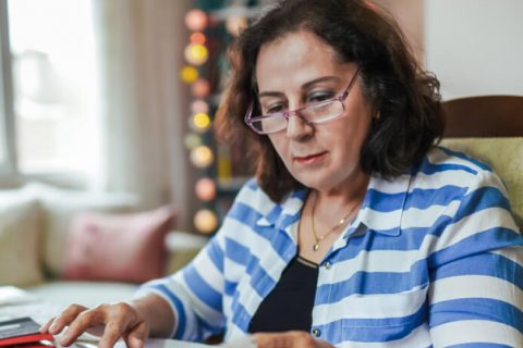 Woman doing her taxes at the dining room table