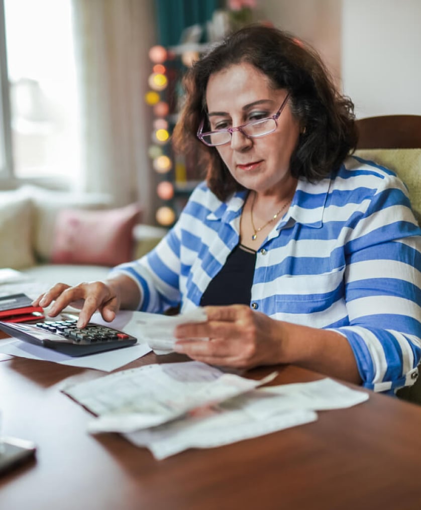 Woman doing her taxes at the dining room table