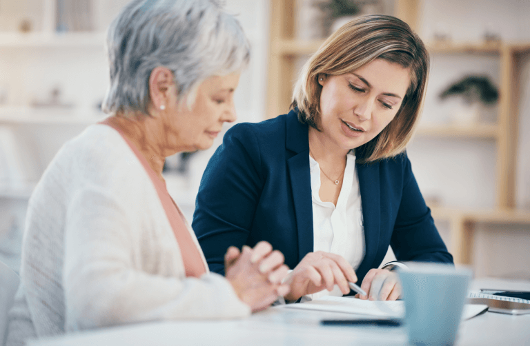 Senior woman looking at paperwork with advisor