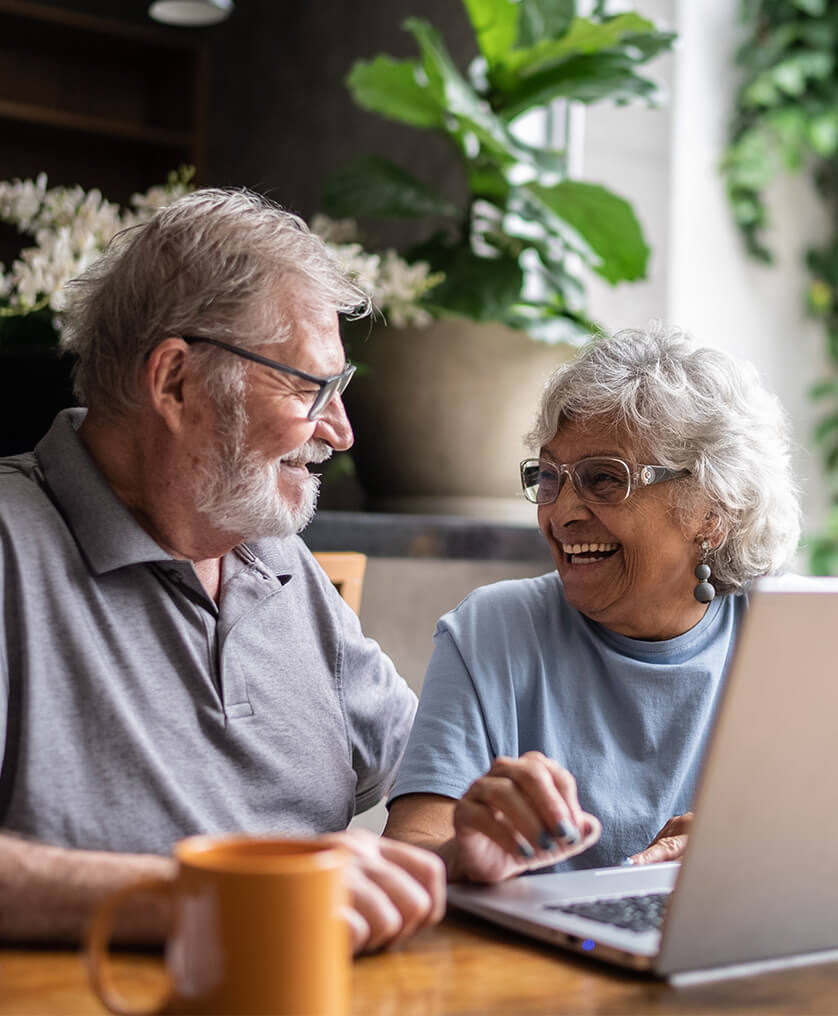 Older adults sitting at table using laptop