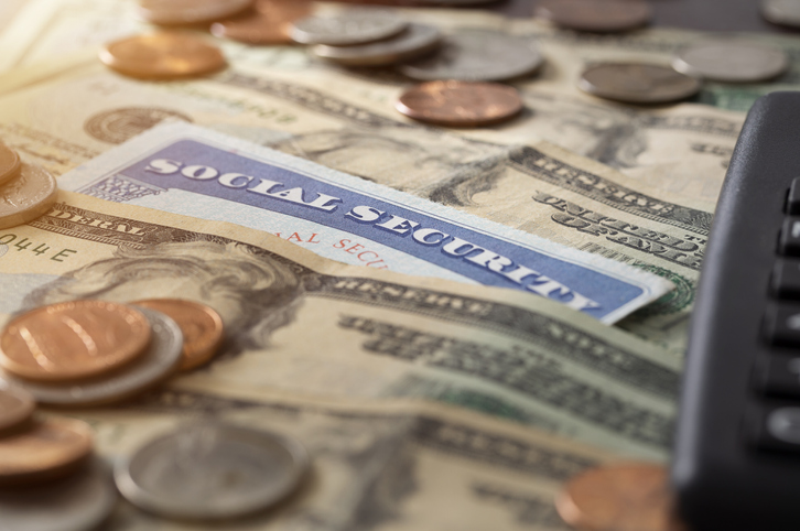 Social Security card sitting on top of money