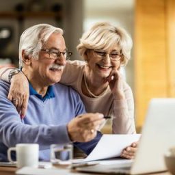 Older couple looking at laptop and papers