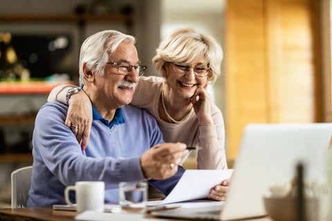 Older couple looking at laptop and papers