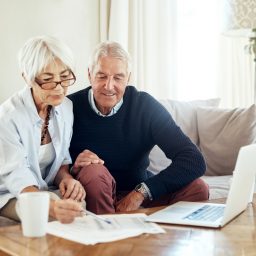 Senior couple sitting in front of computer