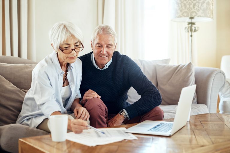 Senior couple sitting in front of computer