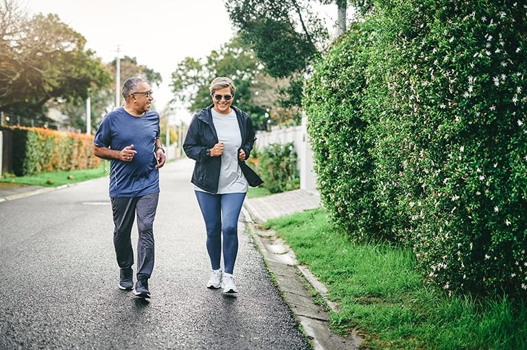 Full length shot of a senior couple bonding together while running outdoors