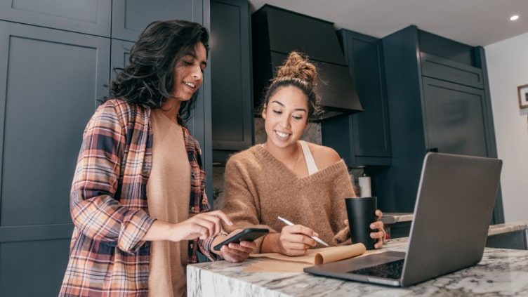 Two women taking notes