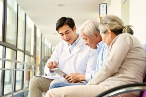 Healthcare professional speaking to elderly couple
