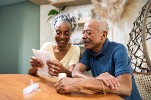 Elderly black couple looking at prescription information