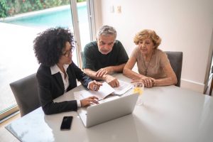 Medicare advisor consulting elderly couple at table