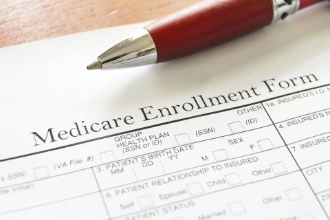 Medicare Enrollment Form and a red pen