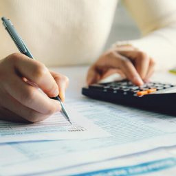 Closeup of woman filling out tax return form