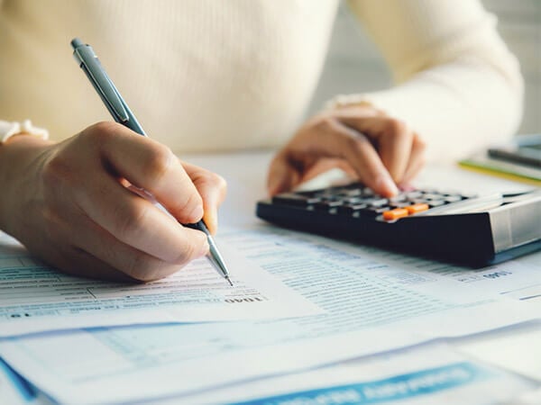 Closeup of woman filling out tax return form