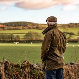 Older man standing alone in a field