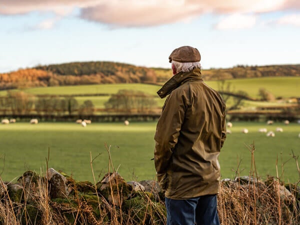 Older man standing alone in a field