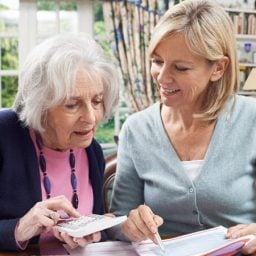 Younger woman helping older woman with finances