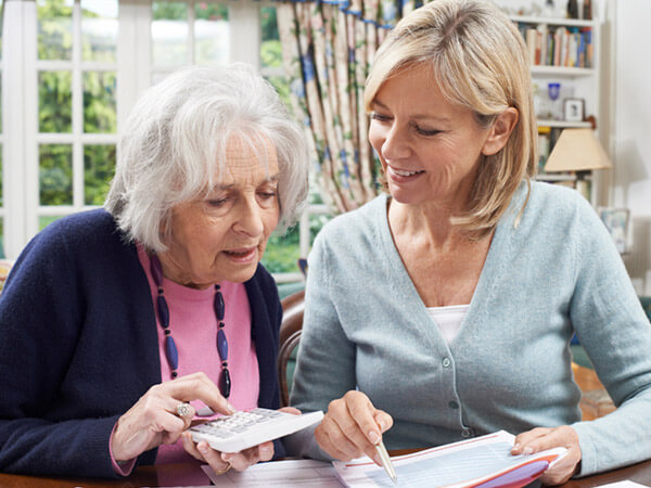 Younger woman helping older woman with finances
