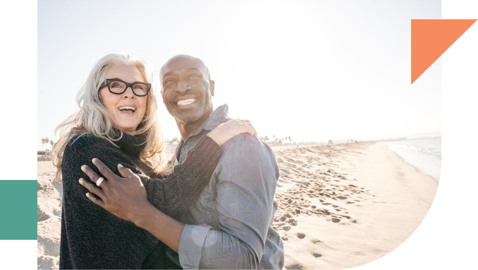 Smiling retired couple on the beach