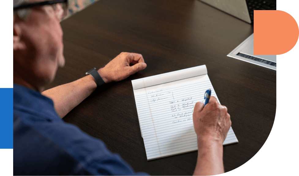 Man writing notes on paper pad