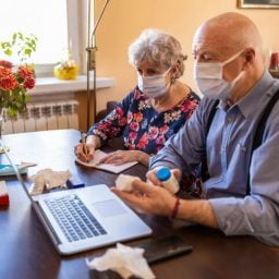 Senior couple consulting with a doctor on laptop at home