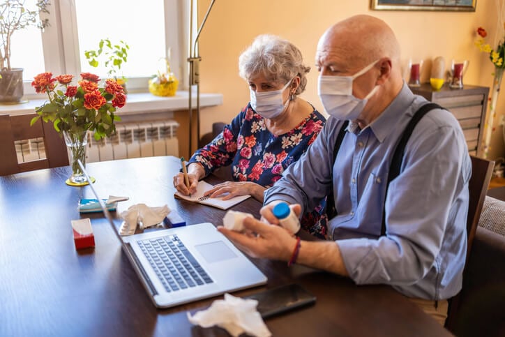 Senior couple consulting with a doctor on laptop at home